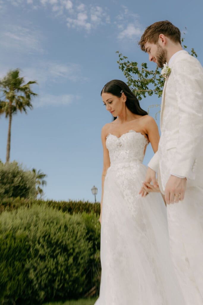 Newlyweds stand hand-in-hand at their wedding villa rome